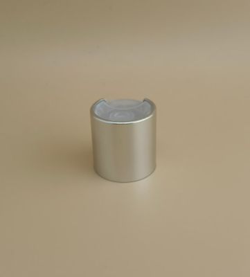 Ασημένιο στρογγυλό καπάκι από αλουμίνιο-πλαστικό με λεία επιφάνεια και διαφανές κουμπί για φιάλες περιποίησης δέρματος